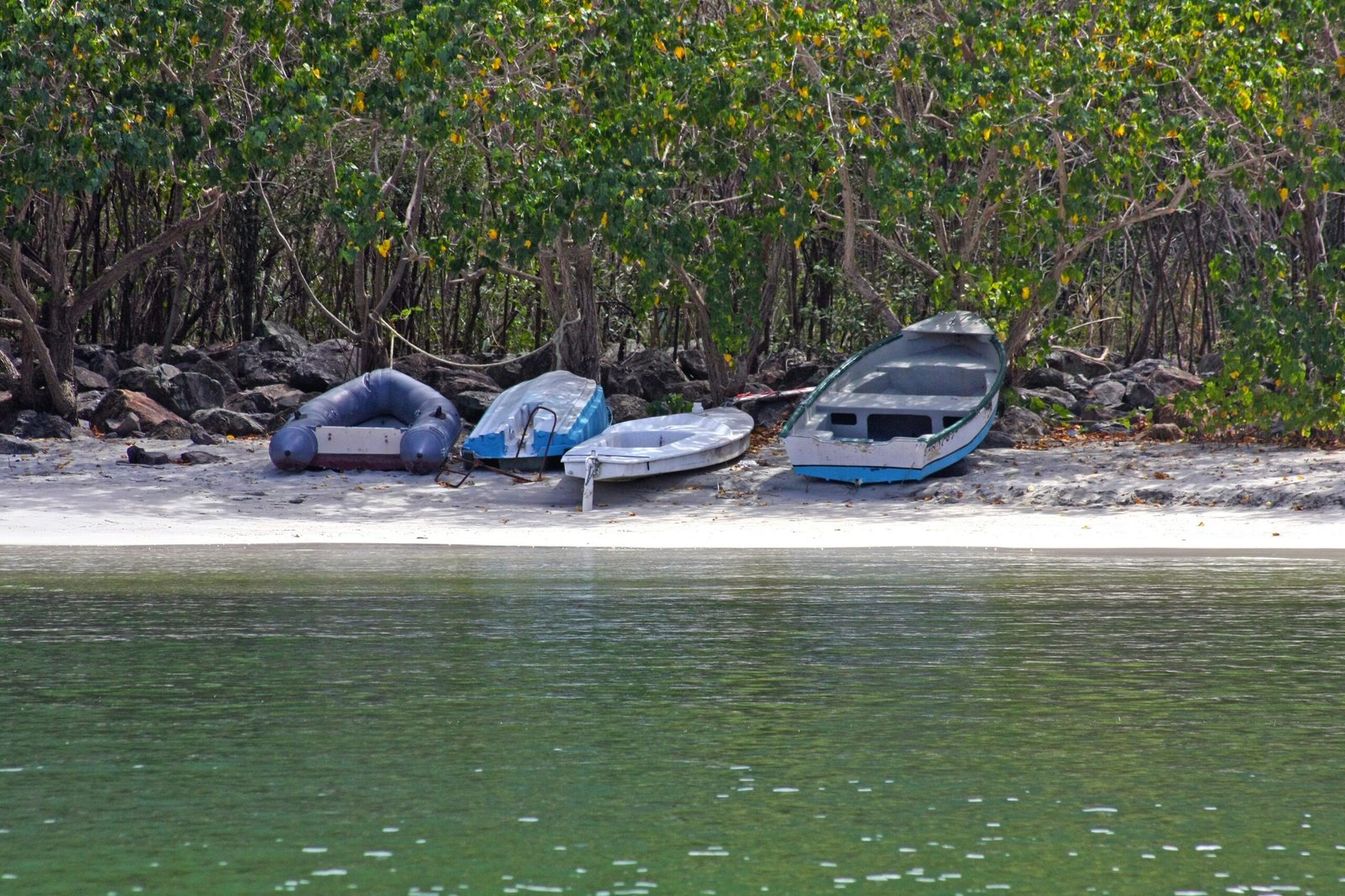a couple of boats sitting on top of a sandy beach